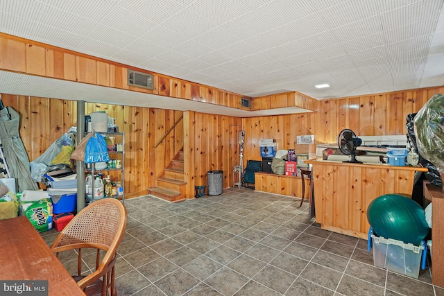 basement with wooden walls and dark tile patterned floors