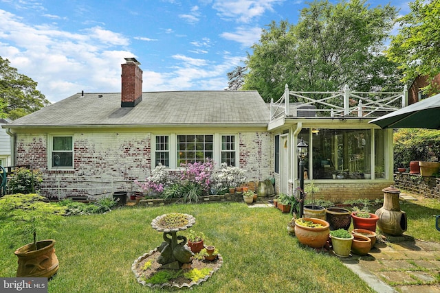 back of property featuring a sunroom and a yard