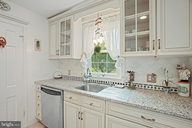 kitchen featuring dishwasher, sink, decorative backsplash, and cream cabinetry