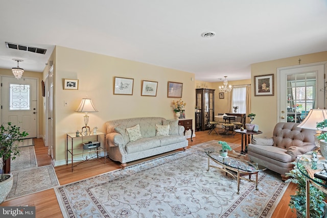 living room with wood-type flooring and an inviting chandelier