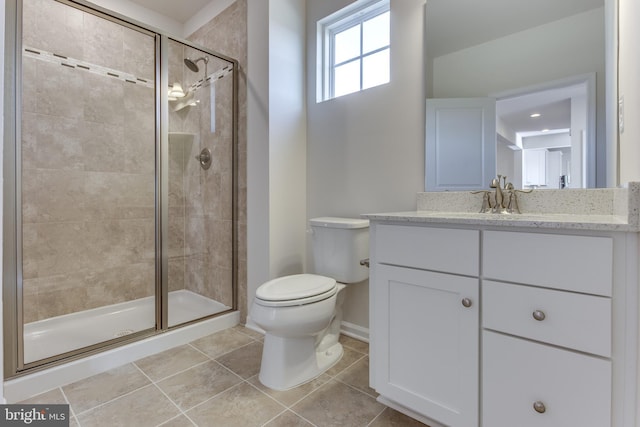 bathroom with vanity, tile patterned floors, a shower with door, and toilet