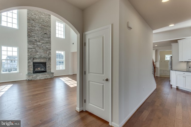 hallway with dark wood-type flooring and a towering ceiling