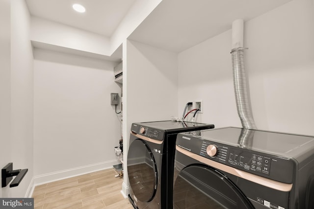 washroom with independent washer and dryer and light hardwood / wood-style flooring