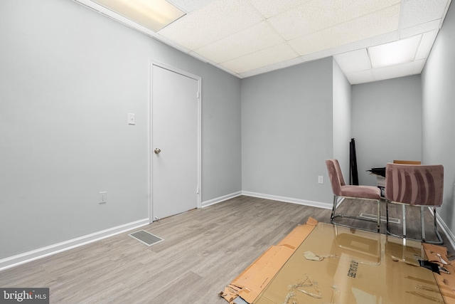 office with wood-type flooring and a paneled ceiling