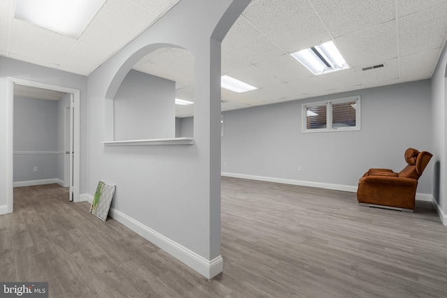 interior space featuring a paneled ceiling and light hardwood / wood-style flooring