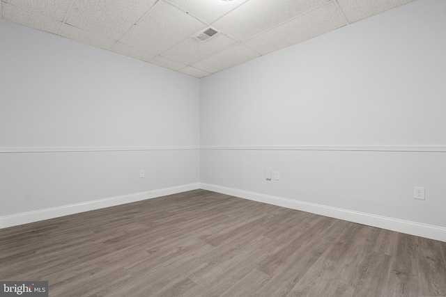 empty room with hardwood / wood-style floors and a drop ceiling