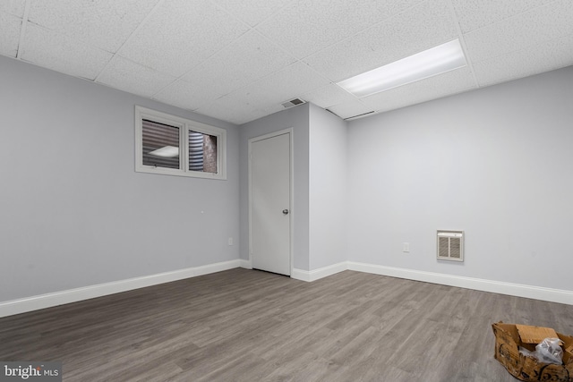 basement featuring wood-type flooring and a paneled ceiling