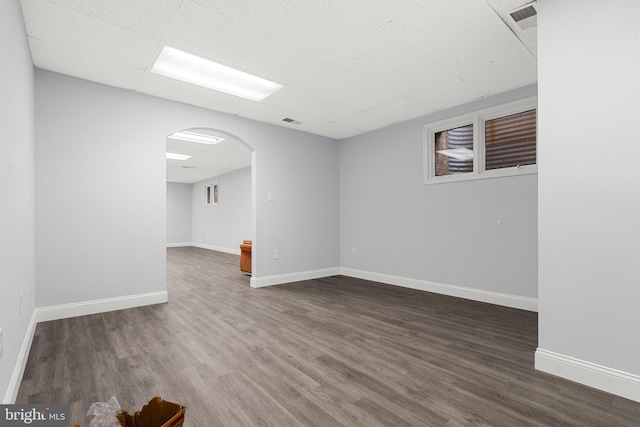 unfurnished room with a drop ceiling and dark hardwood / wood-style floors