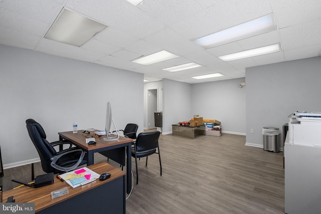 home office featuring a paneled ceiling and dark hardwood / wood-style flooring