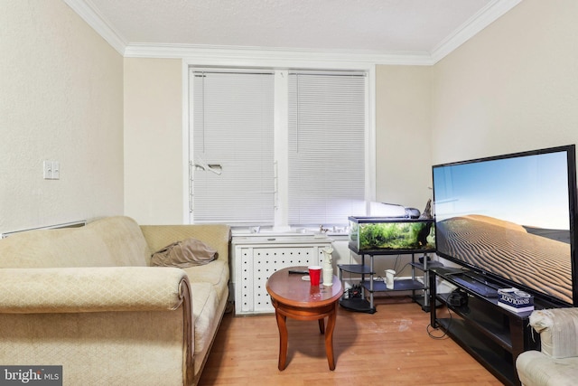 living area with ornamental molding and light hardwood / wood-style flooring