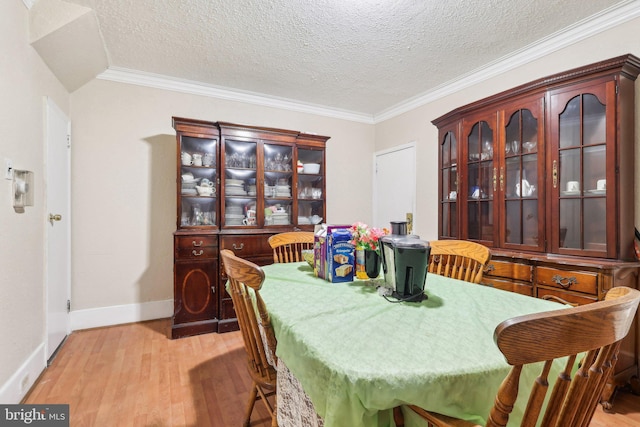 dining room featuring ornamental molding, light hardwood / wood-style flooring, and a textured ceiling