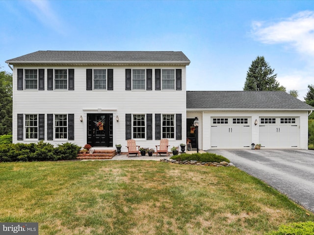 colonial house with a garage and a front lawn