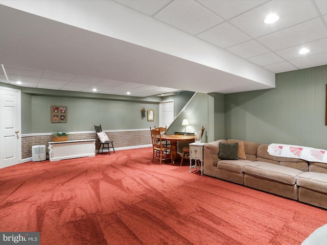 living room featuring a paneled ceiling and carpet