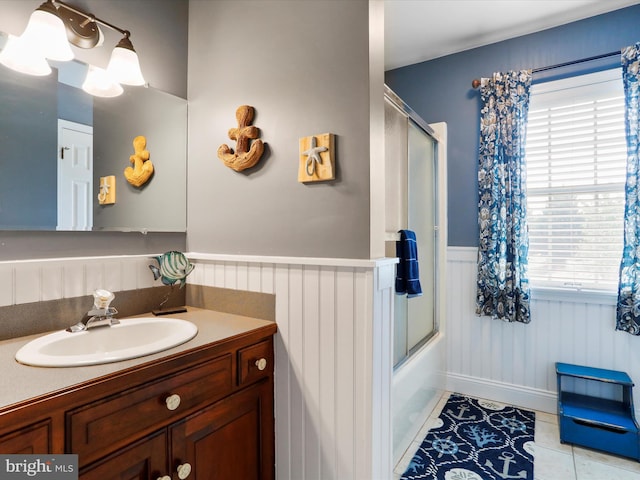 bathroom featuring tile patterned flooring, vanity, and combined bath / shower with glass door