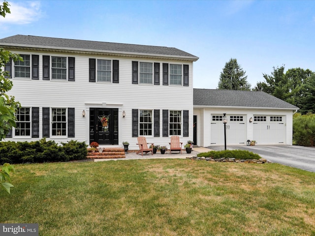 colonial house featuring a garage and a front lawn