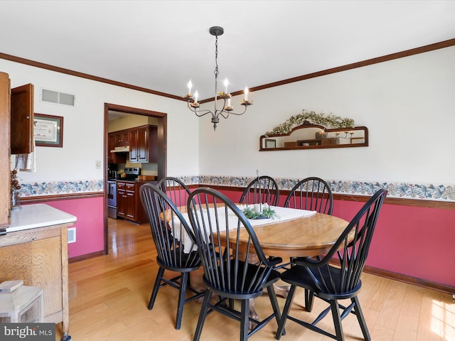 dining room featuring ornamental molding, an inviting chandelier, and light wood-type flooring