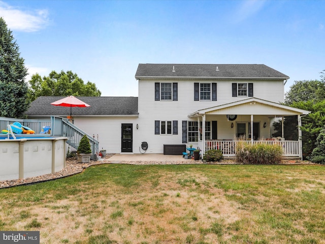 back of house with a patio and a lawn