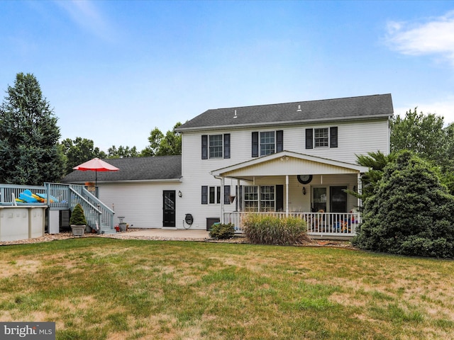 rear view of house with a patio and a lawn