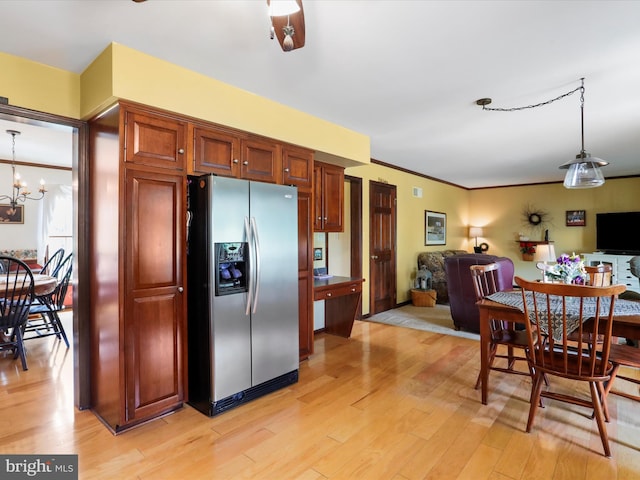 kitchen featuring pendant lighting, light hardwood / wood-style flooring, an inviting chandelier, stainless steel refrigerator with ice dispenser, and ornamental molding