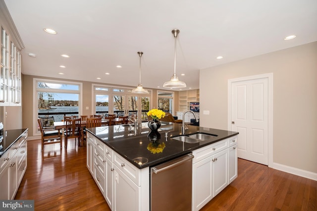 kitchen with sink, stainless steel dishwasher, an island with sink, and white cabinets