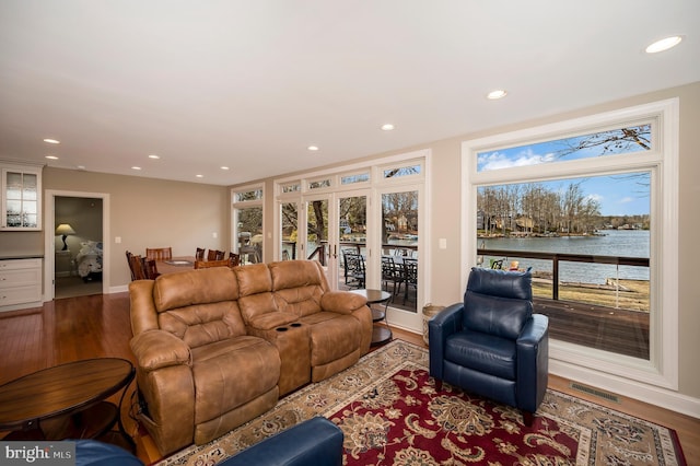 living room featuring a water view and hardwood / wood-style floors