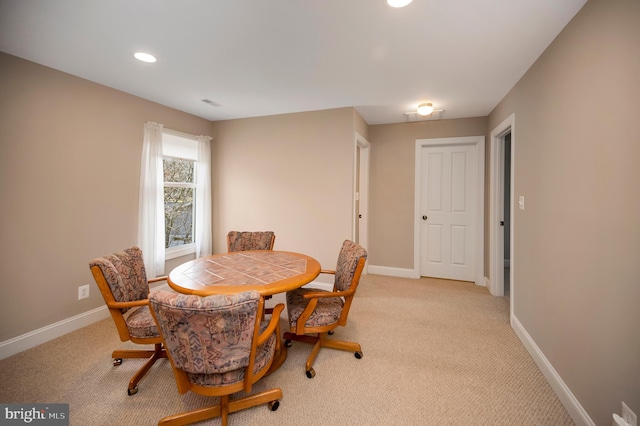 dining space featuring light colored carpet