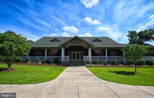 view of front of property featuring a front yard, french doors, and covered porch