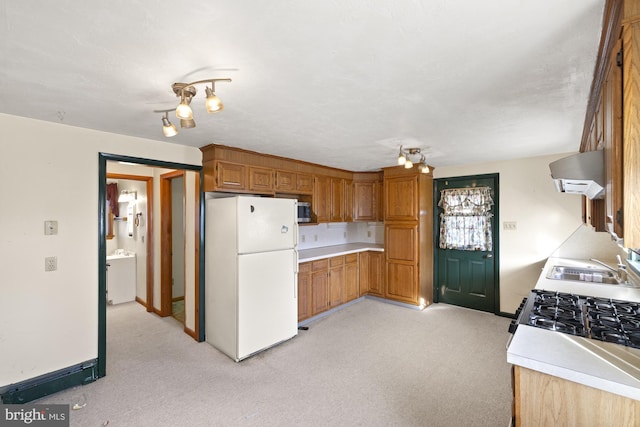 kitchen with white fridge, sink, wall chimney range hood, and light colored carpet