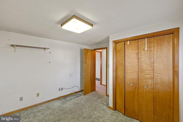 unfurnished bedroom featuring light colored carpet and a closet