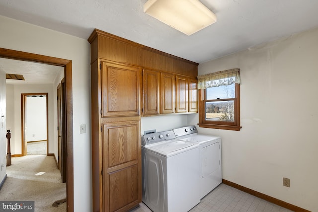 clothes washing area with cabinets and washing machine and clothes dryer