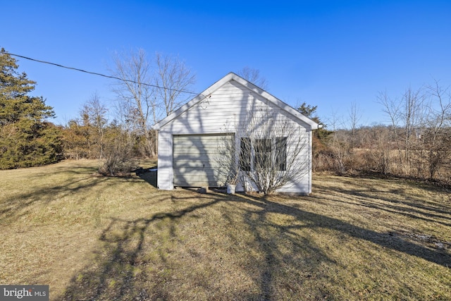 view of outdoor structure with a garage and a lawn