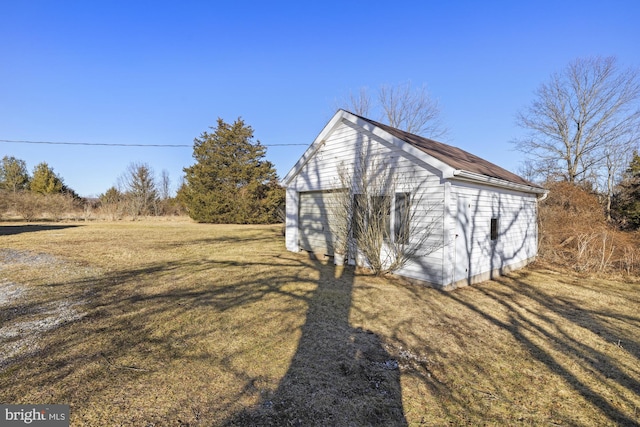 view of home's exterior featuring an outbuilding, a garage, and a lawn