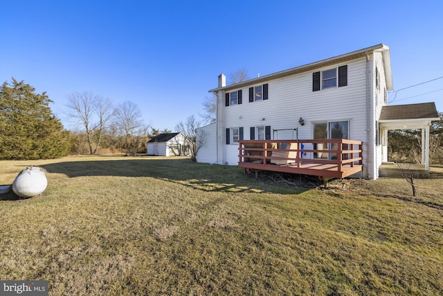 rear view of property featuring a wooden deck and a yard