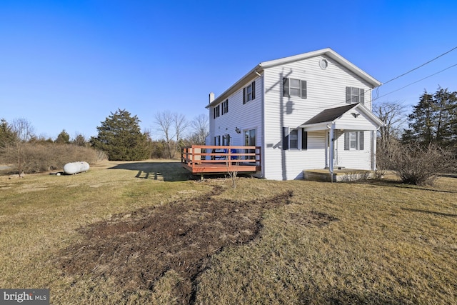 view of side of property featuring a wooden deck and a yard