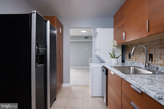 kitchen featuring light tile patterned flooring, sink, black refrigerator with ice dispenser, stainless steel dishwasher, and backsplash