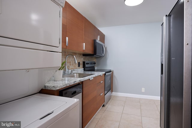 kitchen featuring tasteful backsplash, appliances with stainless steel finishes, light tile patterned flooring, and sink