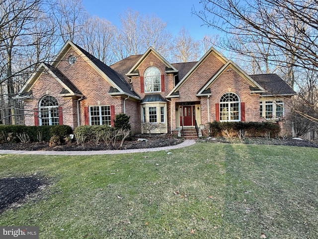 view of front facade featuring brick siding and a front yard