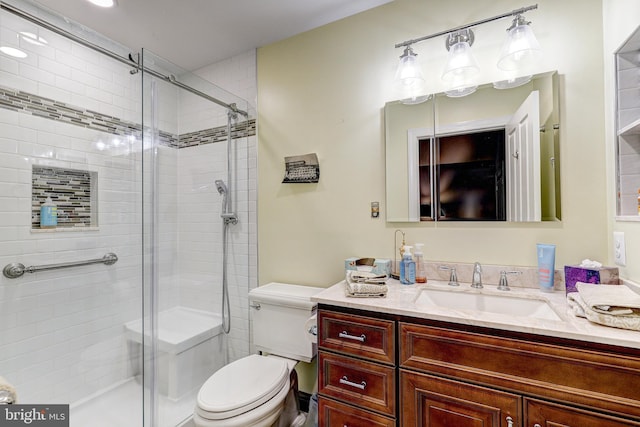 bathroom featuring an enclosed shower, vanity, and toilet