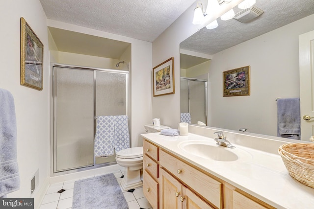 bathroom featuring tile patterned floors, toilet, a textured ceiling, a shower stall, and vanity