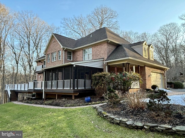 exterior space featuring a garage, a yard, a sunroom, and a deck