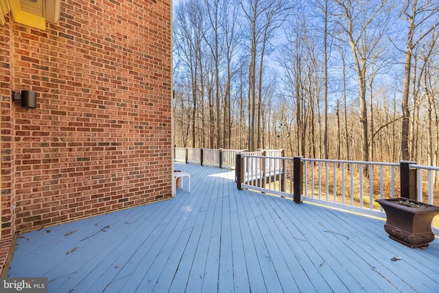 wooden terrace featuring a forest view