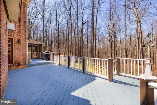 wooden terrace featuring a forest view