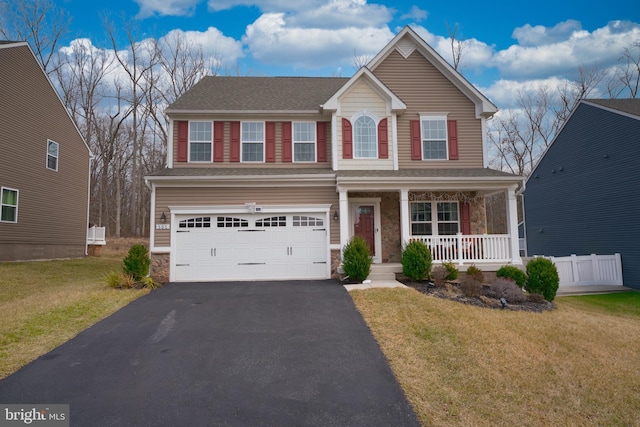 view of front of property with a garage, a front yard, and a porch