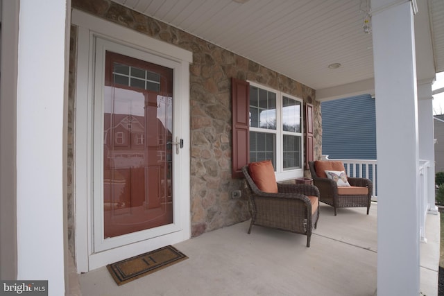 view of exterior entry featuring covered porch