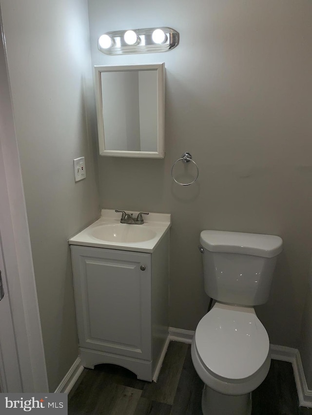 bathroom featuring vanity, hardwood / wood-style flooring, and toilet