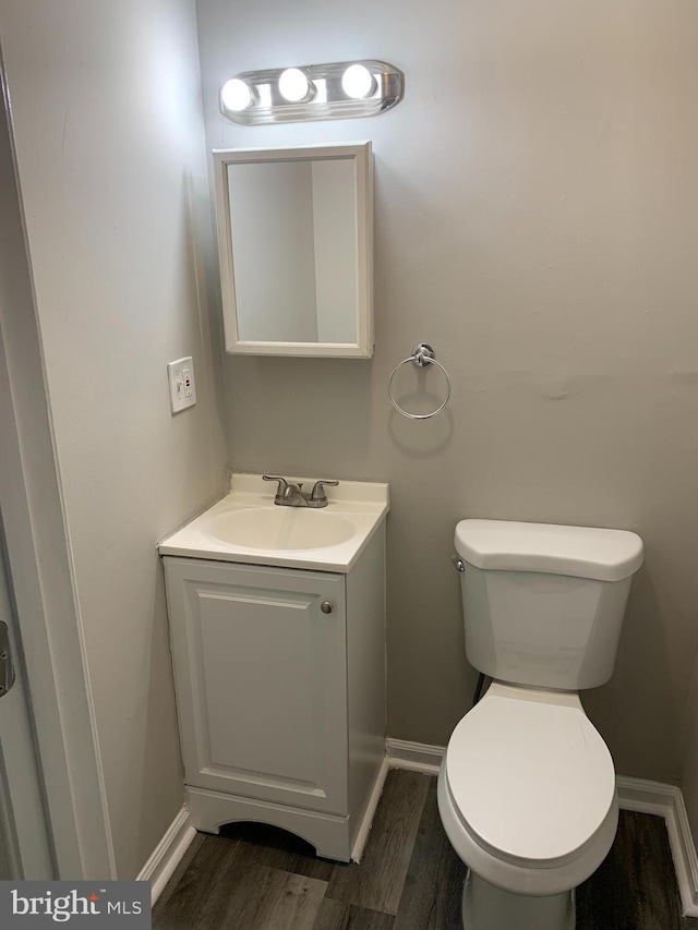 bathroom with wood-type flooring, toilet, and vanity