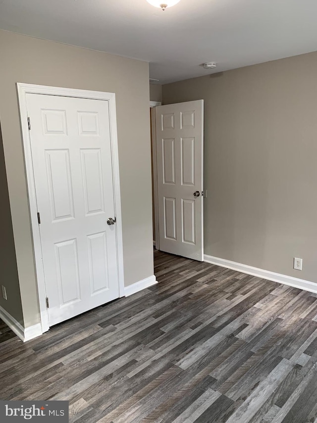 unfurnished bedroom featuring dark hardwood / wood-style flooring