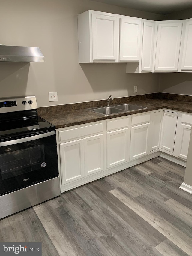 kitchen with white cabinetry, sink, electric range, and light hardwood / wood-style flooring