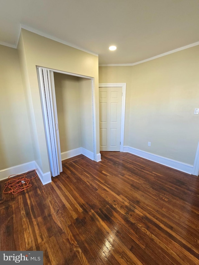 unfurnished bedroom with ornamental molding, dark hardwood / wood-style floors, and a closet