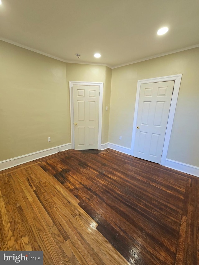 unfurnished bedroom with crown molding and dark hardwood / wood-style floors